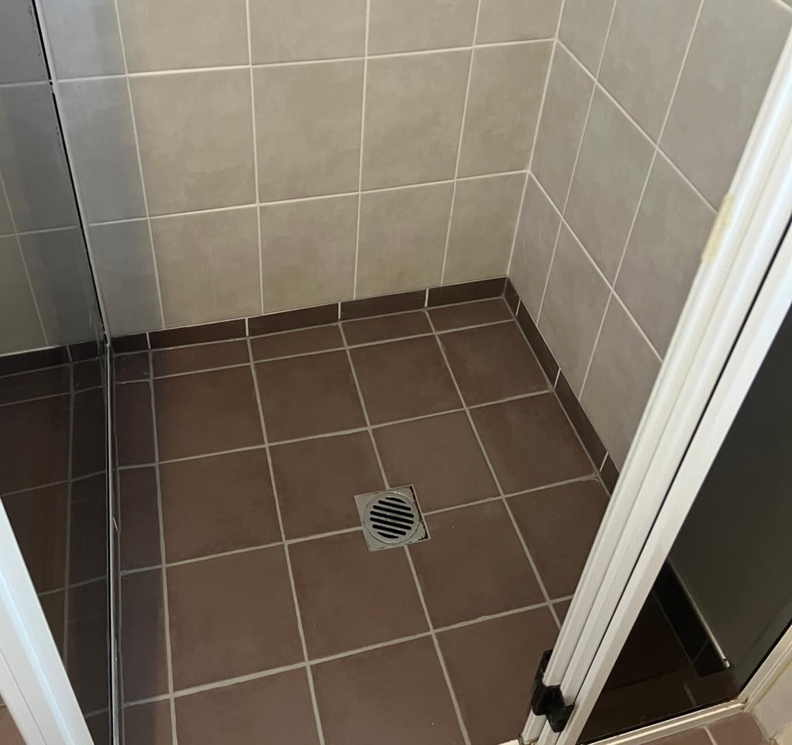 Gold Coast shower regrouting - before: old, cracked grout with mould and water damage
